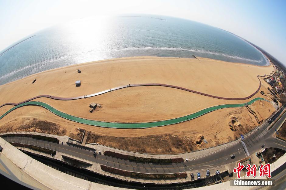 3月13日，秦皇島萬(wàn)米臨海沙灘木棧道。據(jù)了解，該木棧道全長(zhǎng)約4200米，與北戴河區(qū)原有的7500米木棧道對(duì)接后全線(xiàn)總長(zhǎng)度1.17萬(wàn)米，整個(gè)木棧道東起秦皇島體育基地游船碼頭，西至北戴河濕地公園，呈波浪形蜿蜒10.4公里海岸線(xiàn)。 中新社發(fā) 曹建雄 攝 CNSPHOTO